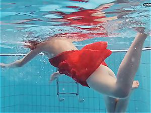 crimson clad teen swimming with her eyes opened